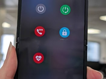 Un téléphone avec un menu de boutons ronds : éteindre, redémarrer, urgence, verrouillage, santé
